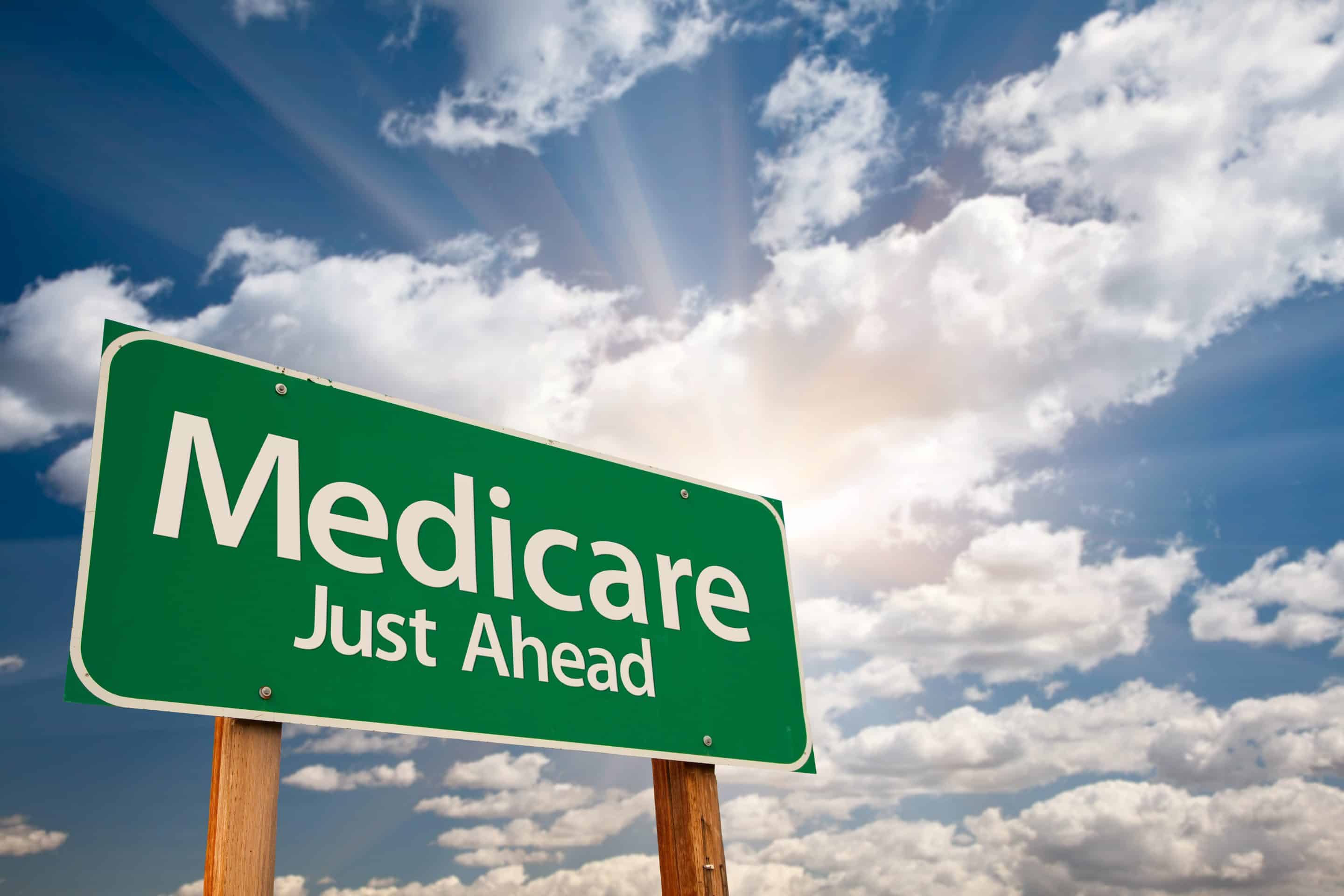 Medicare Green Road Sign Over Dramatic Clouds and Sky. Medicare Ahead at age 65